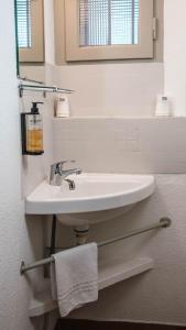 a bathroom with a white sink and a mirror at Marina Hôtel Club in Cogolin