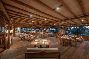 a restaurant with wooden floors and tables and chairs at Jaguaríndia Village in Fortim