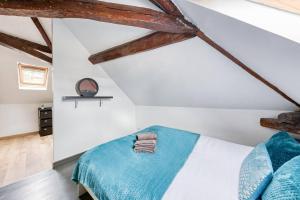 - une chambre avec un lit et une couverture bleue dans l'établissement La Nuit du Drouais - T2 en plein cœur de Ville !, à Dreux