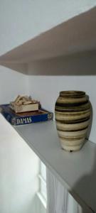 a vase sitting on a shelf next to a book at Piran Loft in Buenos Aires