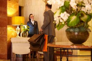 a man and a woman standing next to a table at L'Hotel PortoBay São Paulo in São Paulo