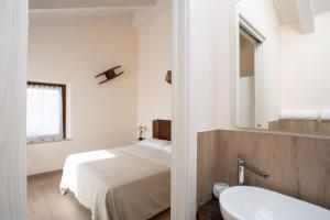 um quarto com uma cama, um lavatório e um espelho em Il Casolare em Gradara