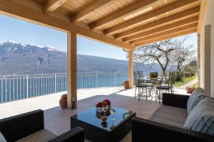 a patio with a table and chairs on a deck at Glicine by Garda FeWo in Tignale