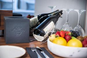 Vogue Hotel Supreme Istanbul في إسطنبول: طاولة مع زجاجة من النبيذ وصحن من الفاكهة