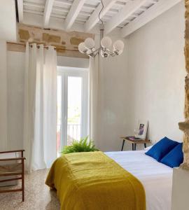 a bedroom with a bed with a yellow blanket at Botánico Casa Rural in Arcos de la Frontera