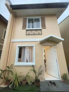 a small house with a white door and some plants at Lily’s Homestay in Butuan