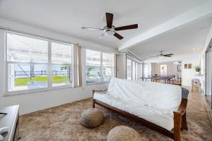 a living room with a couch and a ceiling fan at Heated Pool, Ping Pong Table, Sleeps 10 - Villa Sunset Riverhouse in Cape Coral