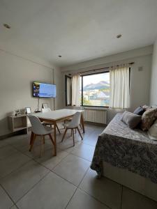 a bedroom with a bed and a table and a television at Departamento Alem 830 in Ushuaia