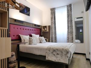 a bedroom with a large bed with a purple headboard at Hôtel Carré Vieux Port in Marseille