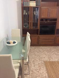 uma sala de jantar com uma mesa de vidro e cadeiras em Casa Gloria 2 em Les Cases d'Alcanar