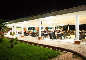 a group of people sitting at tables on a patio at night at Hotel Terramia Resort in Santa Cruz de la Sierra