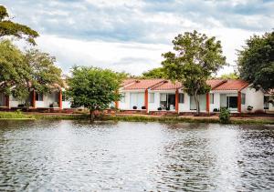 a house with a lake in front of it at Hotel Terramia Resort in Santa Cruz de la Sierra