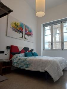 a bedroom with a bed and a painting on the wall at Loft Nou Benicalap in Valencia