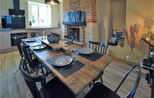 uma mesa de jantar com cadeiras e uma lareira em Stunning Home In Saint-brice-de-landell With Wifi And 3 Bedrooms em Saint-Brice-de-Landelles