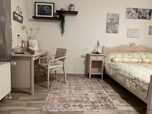 a bedroom with a bed and a table and a desk at Landhaus Pusteblume in Quedlinburg