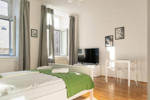 Dormitorio con cama, escritorio y TV en comfortable 3BR -Belvedere -Perfect for long stays, en Viena