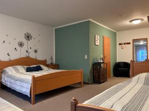 a bedroom with two beds and green walls at Landhaus Pusteblume in Quedlinburg