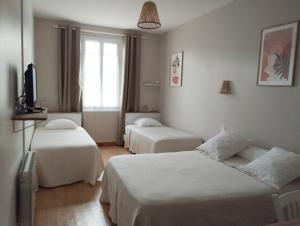Habitación de hotel con 2 camas y TV en le Marronnier en Tramayes