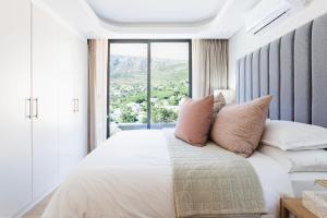 a bedroom with a large bed with a large window at The View - Brand new Penthouse with private rooftop pool in Cape Town