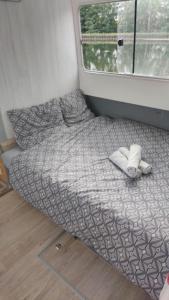 een bed in de hoek van een kamer met een raam bij Nuit insolite péniche bateau Libéllule in Briennon