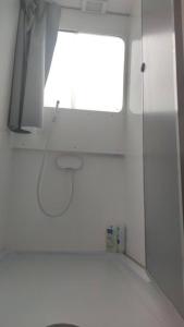 ein weißes Zimmer mit einem Fenster und einer weißen Wand in der Unterkunft Libéllule péniche nuit insolite in Briennon