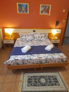 マルゲーラにあるHotel Amba Alagiのベッドルーム1室(ベッド1台、ナイトスタンド2台、ランプ2つ付)