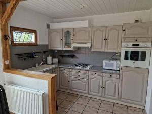 een keuken met witte kasten en een fornuis met oven bij Maison familiale in Duinkerke
