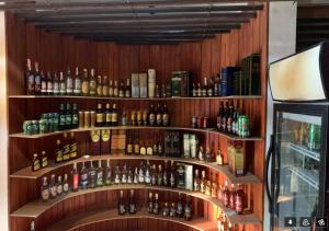 ジャフナにあるSubhas Tourist Hotelのアルコールのボトル入り棚のあるバー