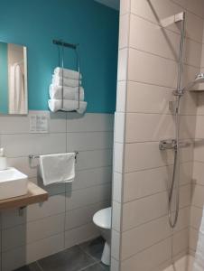 a bathroom with a shower and a toilet and towels at le Marronnier in Tramayes