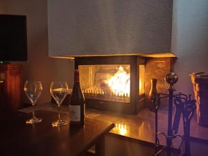 uma garrafa de vinho e dois copos numa mesa com lareira em La casa de la Plaza - WIFI - Barbacoa - Chimenea em Cirueña