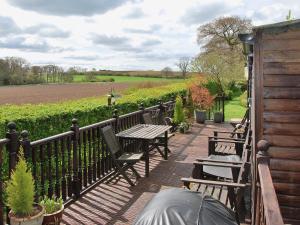 a deck with benches and tables and a field at High Moor Cottage in Dufton