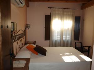 una camera da letto con un grande letto bianco e una finestra di Casa Rural El Olivo a Guijo de Granadilla