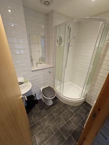 a bathroom with a shower and a toilet and a sink at 65 Renfield st 2 bed Apartment in Glasgow