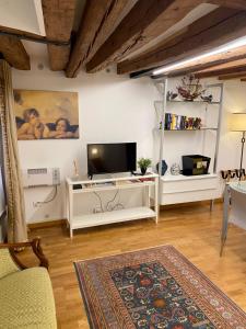 a living room with a television on a white cabinet at San Marco Loft in Venice