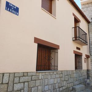- Edificio con puerta y balcón en 6 bedrooms house with city view enclosed garden and wifi at San Bartolome de Pinares, en San Bartolomé de Pinares