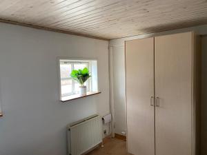 una habitación con un armario y una planta en una ventana en Nyd Naturen på Tåsinge, tæt på Svendborg en Svendborg