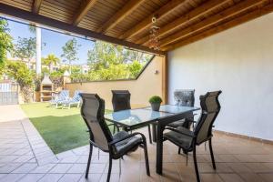 a glass table and chairs on a patio at Villa esclusiva a 300m da Playa del Duque in Adeje