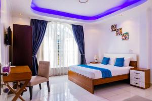 ein Schlafzimmer mit einem Bett mit einer violetten Decke in der Unterkunft Villa Asimba in Kigali + 37 Fotos
