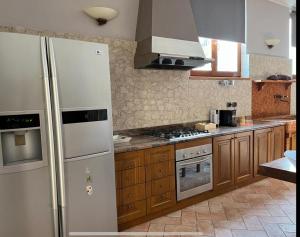 uma cozinha com um frigorífico branco e armários de madeira em Green Woods em Verona