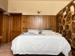 Schlafzimmer mit einem großen weißen Bett und Holzwänden in der Unterkunft Green Woods in Verona