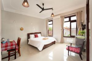- une chambre avec un lit, une table et des chaises dans l'établissement Pink Beach Homestay, à Hội An