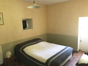 Dormitorio pequeño con cama y lámpara en Maison à la campagne proche d'un centre équestre, en Peyrat-de-Bellac