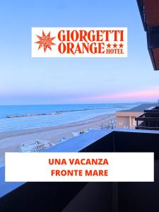 a sign in front of a beach with the ocean at Hotel Giorgetti Orange in Bellaria-Igea Marina