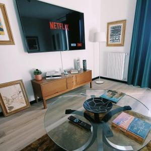 sala de estar con mesa de cristal y TV en ArtGallery Apartment - Villa immersa nel verde - Deluxe, en Viterbo