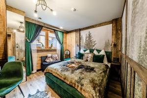 een slaapkamer met een groot bed en een bank bij Brzozowa Osada - Premium Chalets Zakopane in Zakopane