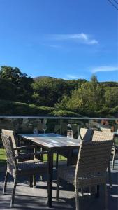a table and chairs on a patio with a view at 173A Woodland Way in Porthmadog