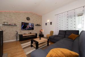 a living room with a couch and a tv on a brick wall at Villa Fina in Tučepi