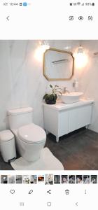 a bathroom with a white toilet and a sink at Preun Jeju Pension in Seogwipo