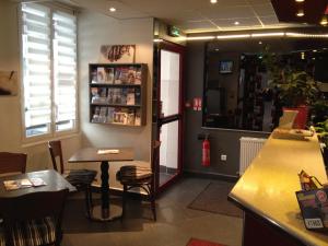 a restaurant with a counter and a table and chairs at Hôtel de l'Europe in Paris