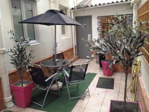 een tafel en stoelen met een parasol op een patio bij Hôtel de l'Europe in Parijs